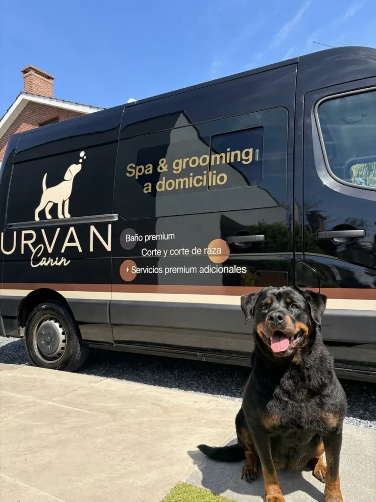 Rottweiler frente a la van de Urvan Canin, estacionada en la puerta de su casa